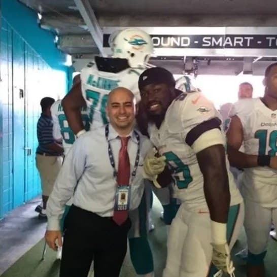 Dr. Abbasi with a Miami Dolphins player in the stadium tunnel