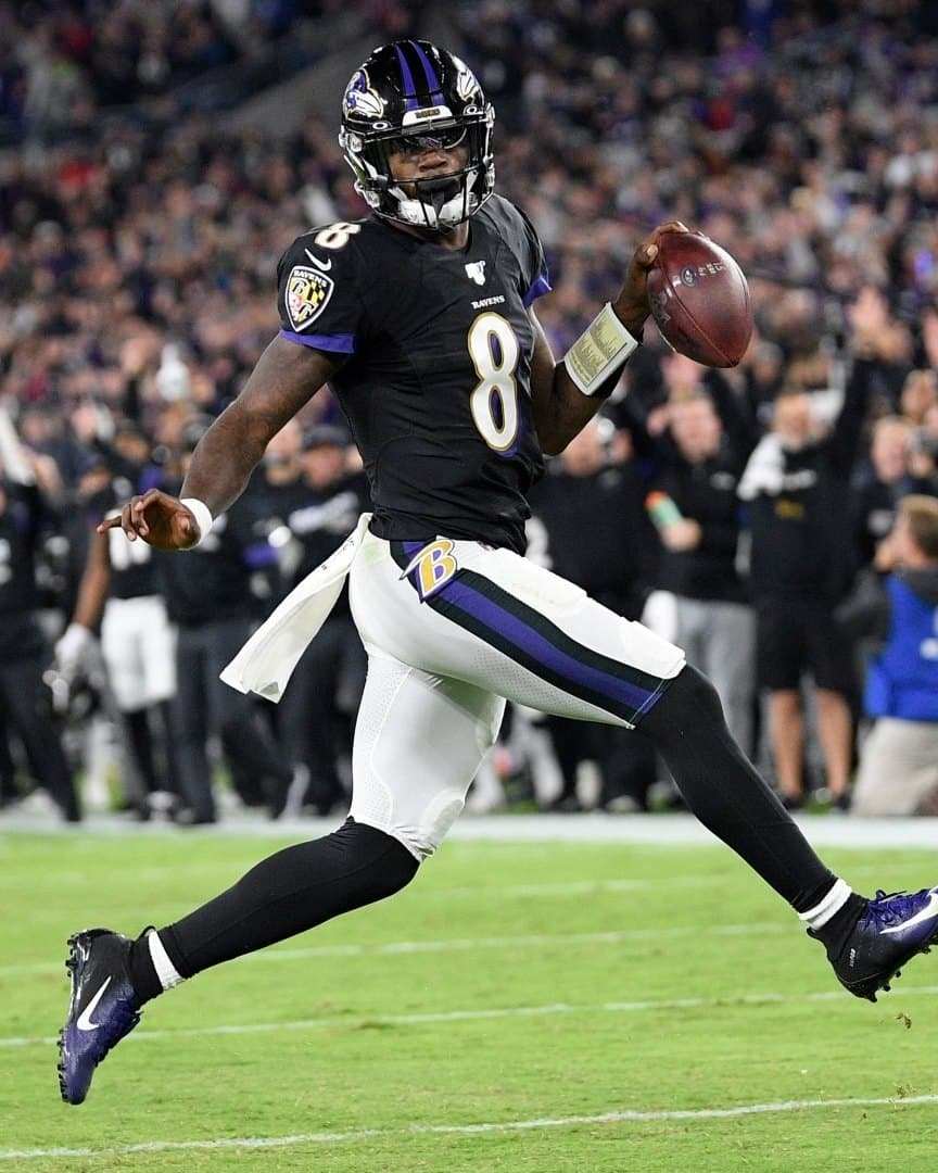 Lamar Jackson running with the ball for the Baltimore Ravens